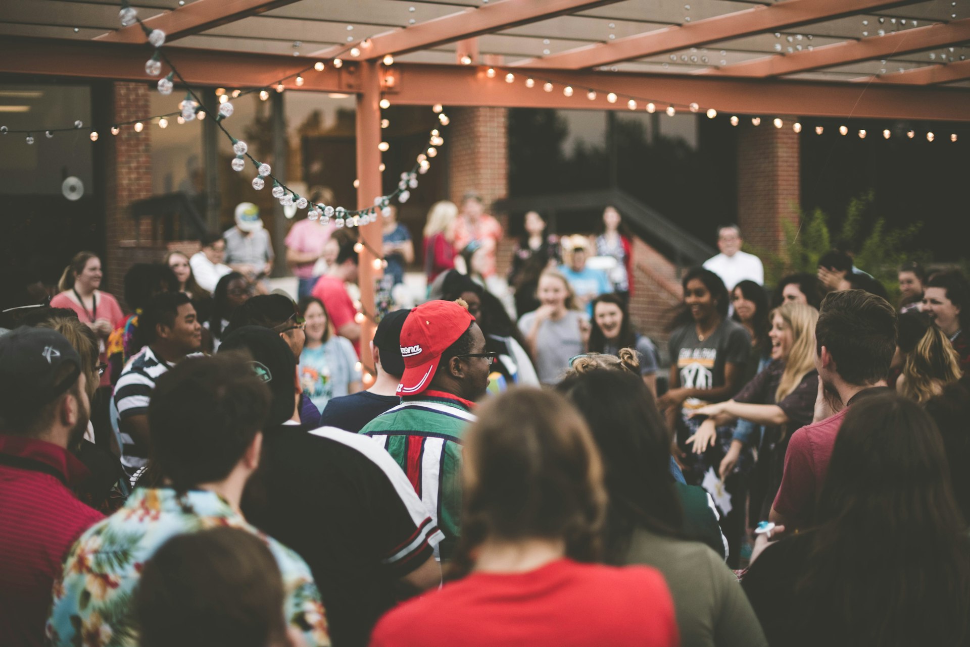 Outdoor gathering under string lights at a venue